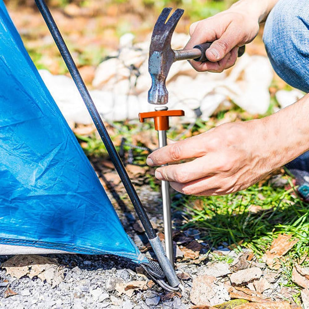 Person setting up a tent with a hammer and tent peg in an outdoor setting
